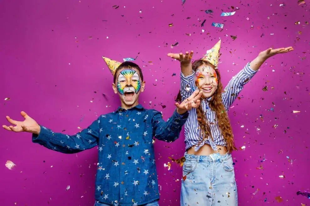 Un garçon et une fille profitent des confettis et sont déguisés pour la fête